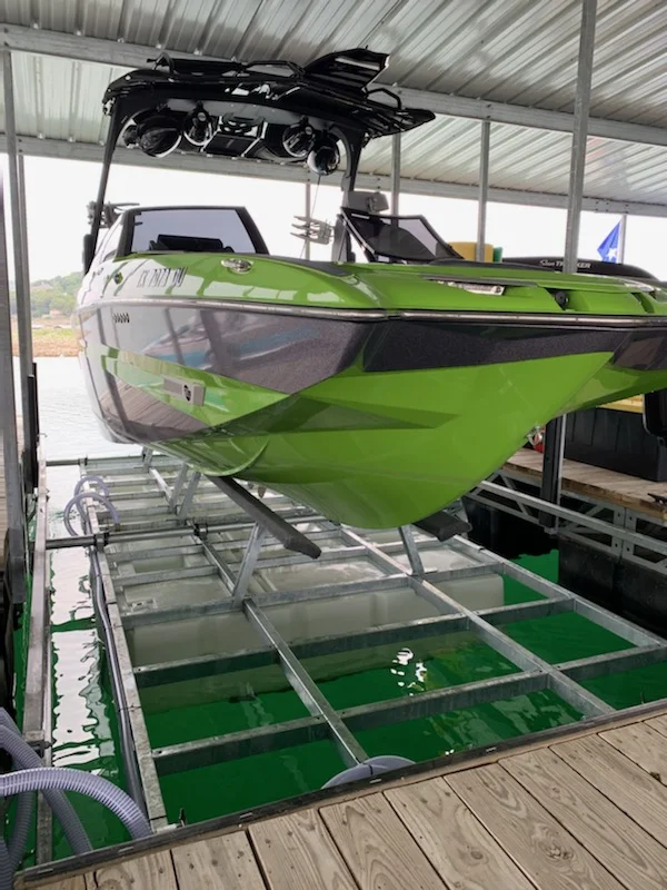 A wake boat raised on the Econo Lift Meridian 10,000 lb side mount lift